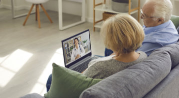 Elderly couple having a virtual consultation with a sleep doctor on a laptop