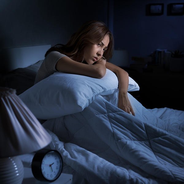 woman sitting in bed cannot sleep from insomnia