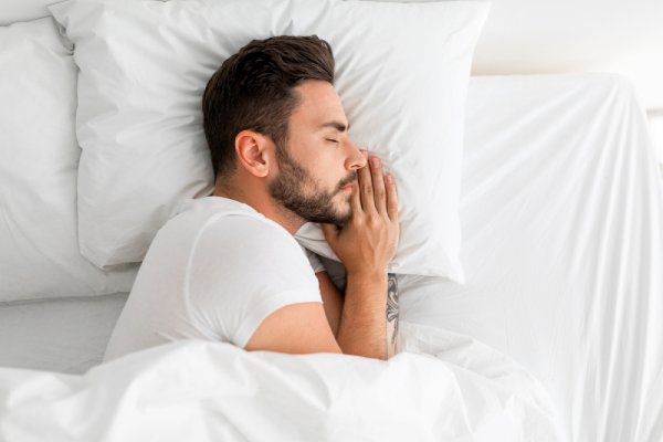 man having deep sleep lying on the bed