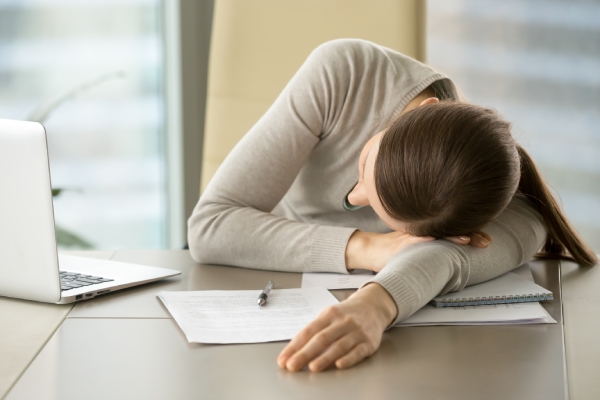 female-employee-sleeping-on-office-desk-during-work